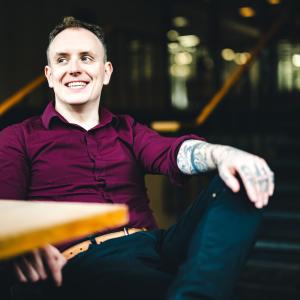 Daniel Laverty sits at a table for a portrait.