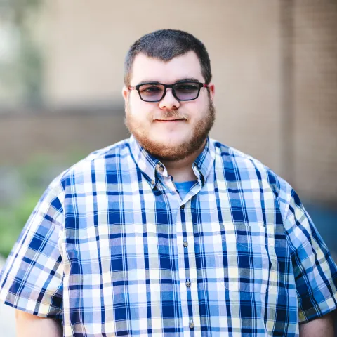 Jonathan Hixson-Cooper standing in front of a brick building