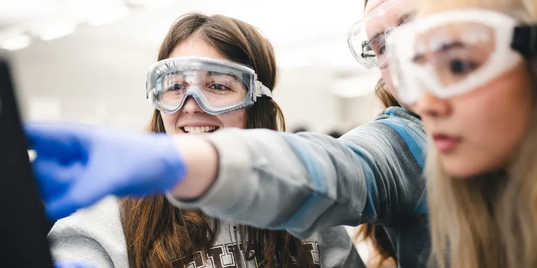 Three chemistry students around a computer. 