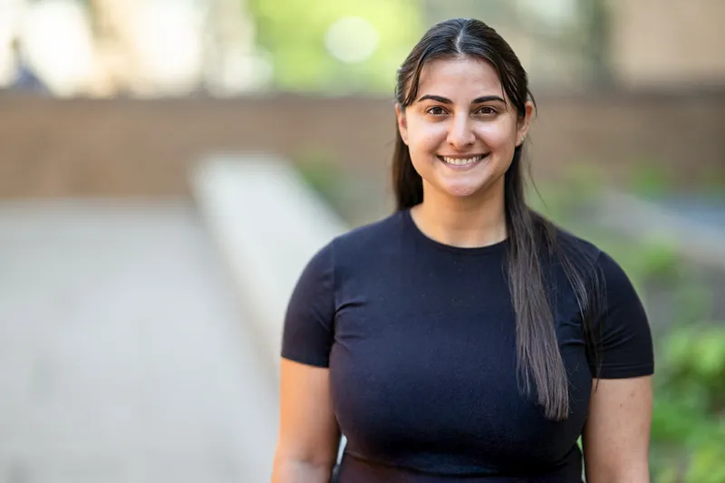 Andrea Dorsa standing in front of brick building wearing a black t-shirt.